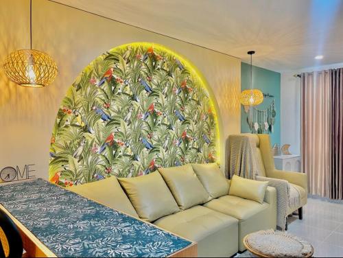 a living room with a large peacock painting on the wall at M&B Tropical 3-Bedroom Townhouse at PonteFino Prime in Batangas City