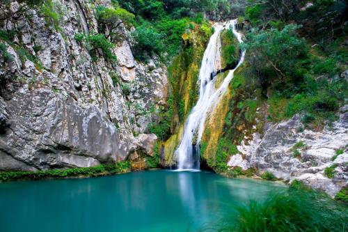 a waterfall in the middle of a lake at Mila House in Mouresi