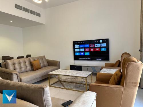 a living room with couches and a flat screen tv at 3BR Amazing Seaview Private Villa with Pool in Fujairah