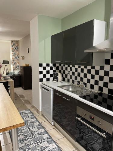 - une cuisine avec un mur en damier noir et blanc dans l'établissement Le Nid Des Canaux au cœur de Bergues, à Bergues