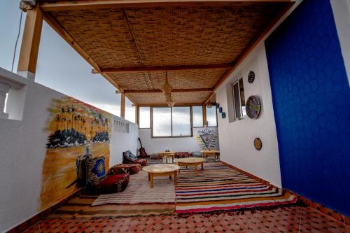 a living room with a blue wall and a table at Ossmon Surf House - Anza in Agadir