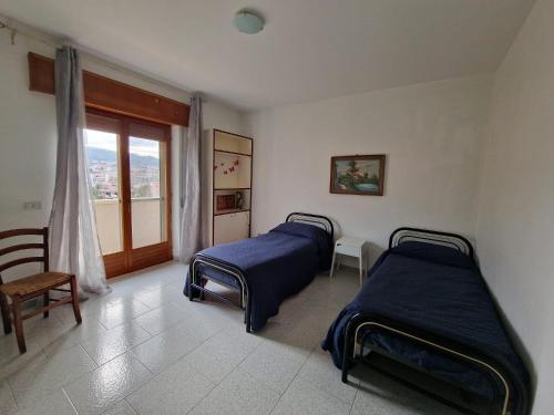 two beds in a room with a window at Vista Monte Retreat in Reggio di Calabria