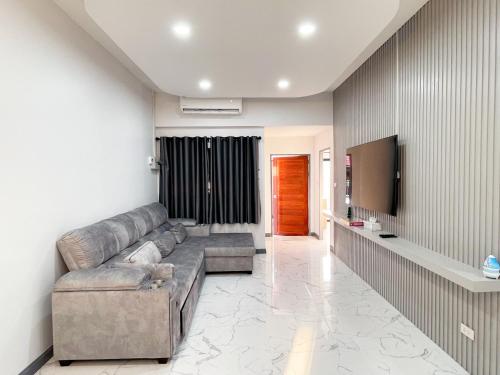 a living room with a couch and a flat screen tv at 4BR Home with large beds near mall & beaches in Ban Tha Rua