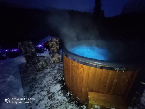 a hot tub in the snow at night at Apartamenty u Joli in Wisła