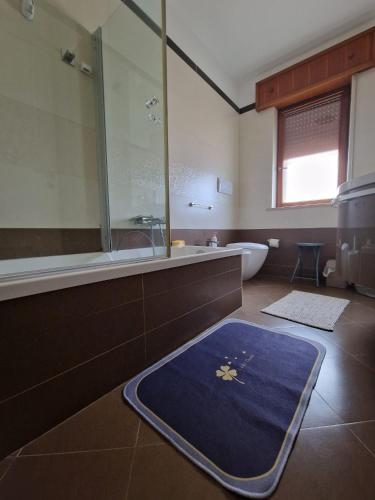 a bathroom with a tub and a blue rug on the floor at Vista Monte Retreat in Reggio di Calabria