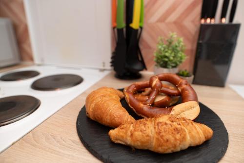 a plate with a pretzel and croissants on a counter at Helle Wohnung mit Balkon perfekt für Monteure und Arbeiter in Rüsselsheim
