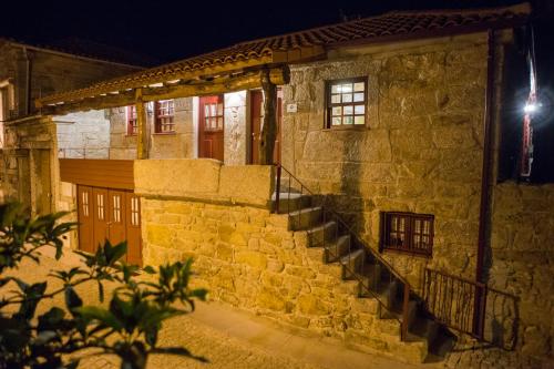 a stone building with stairs in front of it at night at Casa da Teresina in Sistelo