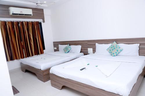 Postel nebo postele na pokoji v ubytování Hotel Matoshree