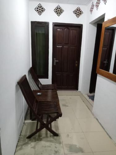 a wooden chair sitting in front of a door at Gili Azwa Homestay in Tanjung