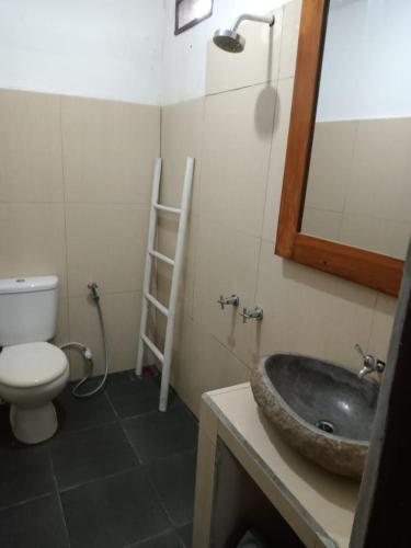 a bathroom with a sink and a toilet and a mirror at Gili Azwa Homestay in Tanjung