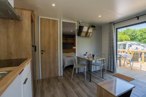 une cuisine et une salle à manger avec une table et des chaises dans l'établissement CAMPING KAYSERSBERG, à Kaysersberg