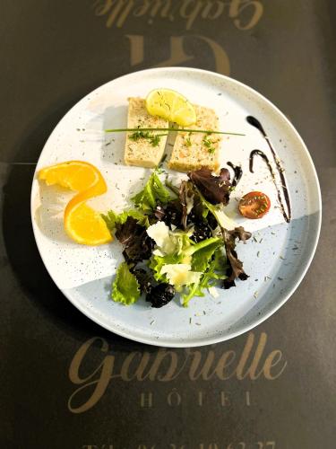 a white plate with food on a table at Gabrielle hôtel in Aiguines