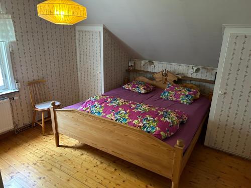 a bedroom with a wooden bed with a purple comforter at Holmsel in Vidsel