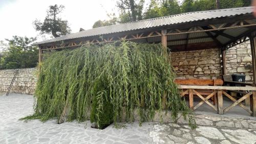 a pavilion with a pile of grass next to a bench at Green garden Կանաչ այգի in Ijevan