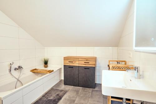 a white bathroom with a sink and a tub and a sinkessment at Ferienwohnung Muthenthaler, Wachau in Schwallenbach