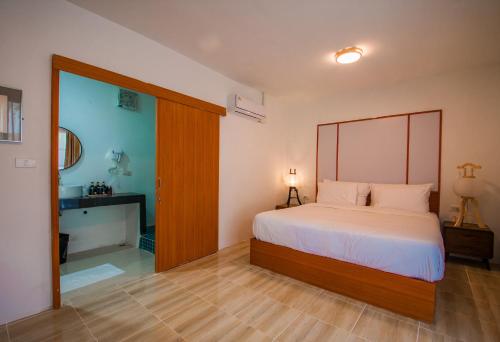 a bedroom with a bed and a sliding glass door at Tani Ryu River Kwai in Ban Tha Pong (1)