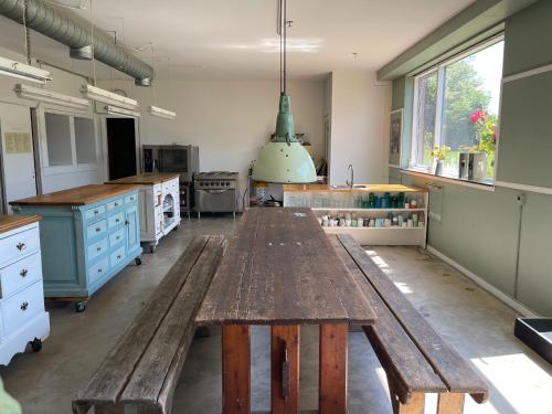 a large kitchen with a wooden table in the middle at Eventyrligt og rummeligt hus med havudsigt in Borre