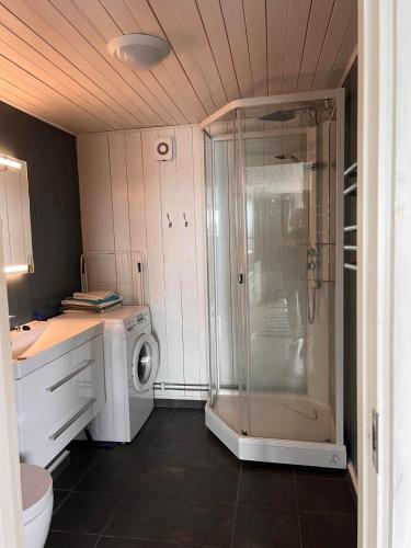 a bathroom with a shower and a washing machine at Yttervik gard in Steinkjer