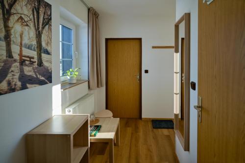 a room with a hallway with a door and a table at Pension Korýtko in Horská Kvilda
