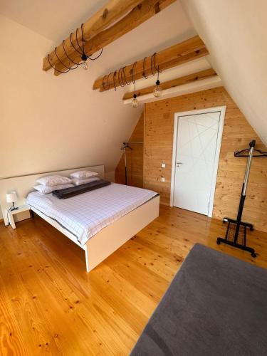 a bedroom with a bed and a wooden floor at Pine Cabins Zlatibor in Zlatibor