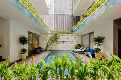 an indoor pool in a building with plants at The Nam An Villa Hoi An in Hoi An