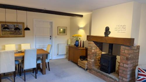a living room with a fireplace and a dining room table at The Old Coach House in Stratford-upon-Avon