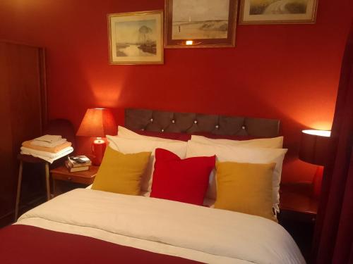 a bedroom with a bed with red and yellow pillows at Cosy Stay in Walsall by Ideal Home in Bloxwich