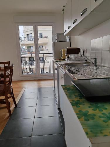 une cuisine avec une cuisinière et un comptoir dans l'établissement Perle de Saint-Ouen - 6 à 8 personnes, à Saint-Ouen