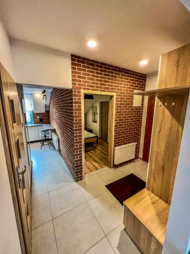 a living room with a brick wall and a kitchen at Wodna 16 premium in Konin
