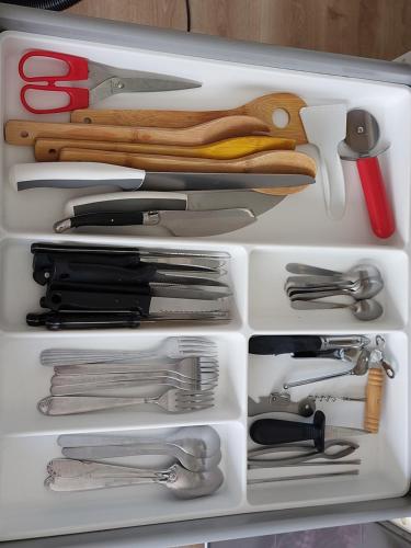 un tiroir blanc rempli de nombreux ustensiles de cuisine dans l'établissement Studio la Salicorne au Sables d'Olonne, à Les Sables-dʼOlonne