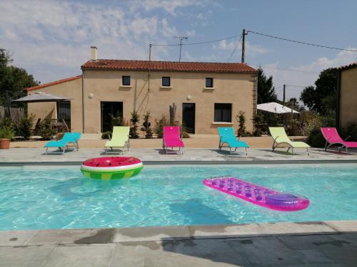 - une piscine avec un bateau à jouets et des chaises dans l'établissement Gîte pOm de Reinette, aux Herbiers