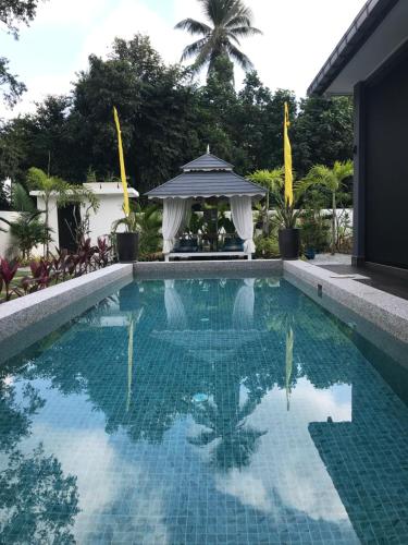 a swimming pool with a gazebo at Villa Beau Rivage in Bachok