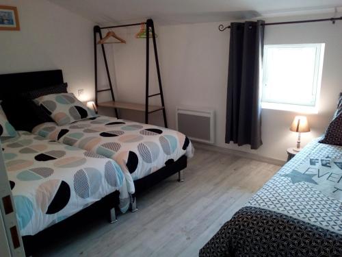 une chambre avec deux lits et une fenêtre dans l'établissement Gîte pOm de Reinette, aux Herbiers