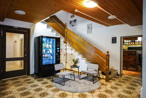 a lobby with a staircase and two chairs and a table at Edelweiss Lodge Lachtal I Self Check-in in Lachtal