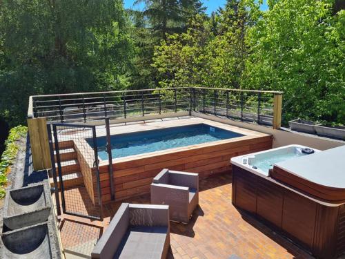 un bain à remous installé au-dessus d'une terrasse dans l'établissement Chambre Seule avec Salle de bain privative - Le Moulin des Poètes, à Malauzat