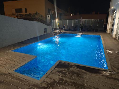 Una gran piscina azul por la noche en Residencial Melba, en Funchal
