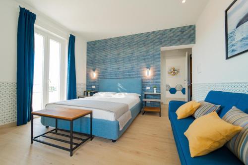 a bedroom with a bed and a blue couch at CàSolare Country House in Sperlonga