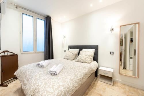 une chambre avec un grand lit avec des serviettes dessus dans l'établissement 1-Br Apartment with AC in the Heart of Cannes, à Cannes