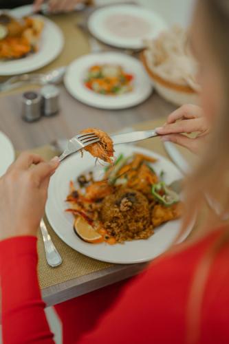 a woman eating a plate of food on a table at Sky Star Hotel free shuttle to Hurghada City center in Hurghada