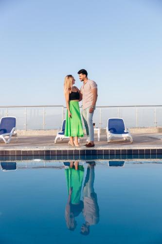 a man and a woman standing next to a swimming pool at Sky Star Hotel free shuttle to Hurghada City center in Hurghada