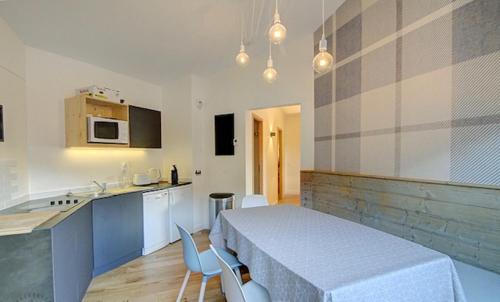 a kitchen with a table and chairs in a room at Appartement familial - La Tania in La Tania