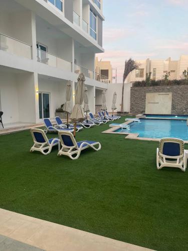 a group of lounge chairs and a swimming pool at Sky Star Hotel free shuttle to Hurghada City center in Hurghada