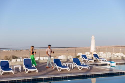 a man and a woman standing next to a swimming pool at Sky Star Hotel free shuttle to Hurghada City center in Hurghada