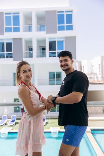 a man and a woman standing next to a pool at Sky Star Hotel free shuttle to Hurghada City center in Hurghada