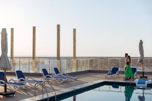 a man standing on the roof of a building with a pool at Sky Star Hotel free shuttle to Hurghada City center in Hurghada