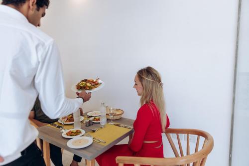 a man handing a woman a plate of food at a table at Sky Star Hotel free shuttle to Hurghada City center in Hurghada