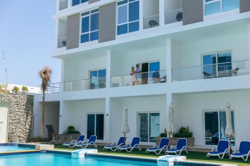 a view of a building with chairs and a swimming pool at Sky Star Hotel free shuttle to Hurghada City center in Hurghada