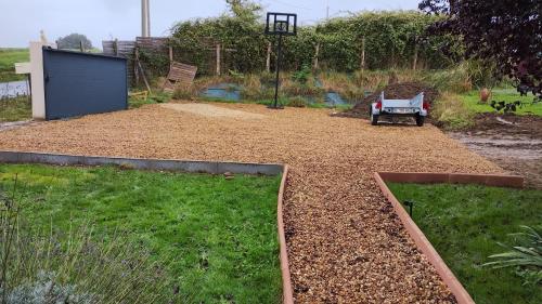 a garden with two beds of dirt and grass at La belle étape bercéenne au calme de sa campagne près circuit Mans Sud in Marigné-Laillé