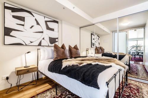 two beds in a bedroom with mirrors at VAQUAY Alkina In Hawthorn in Melbourne