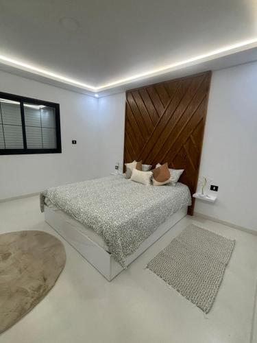 a bedroom with a bed with a wooden headboard at Villa Benbienn piscine iptv Billard américain wifi illimité très bon emplacement in Taguermess